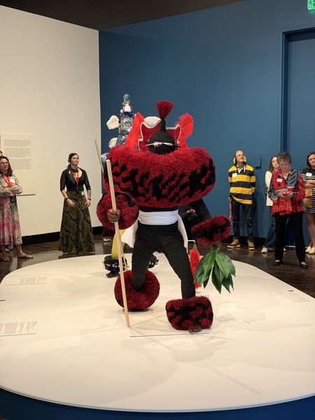 Una figura de mascarada africana en rojo y negro en exhibición en la galería del Frist Art Museum en Nashville.